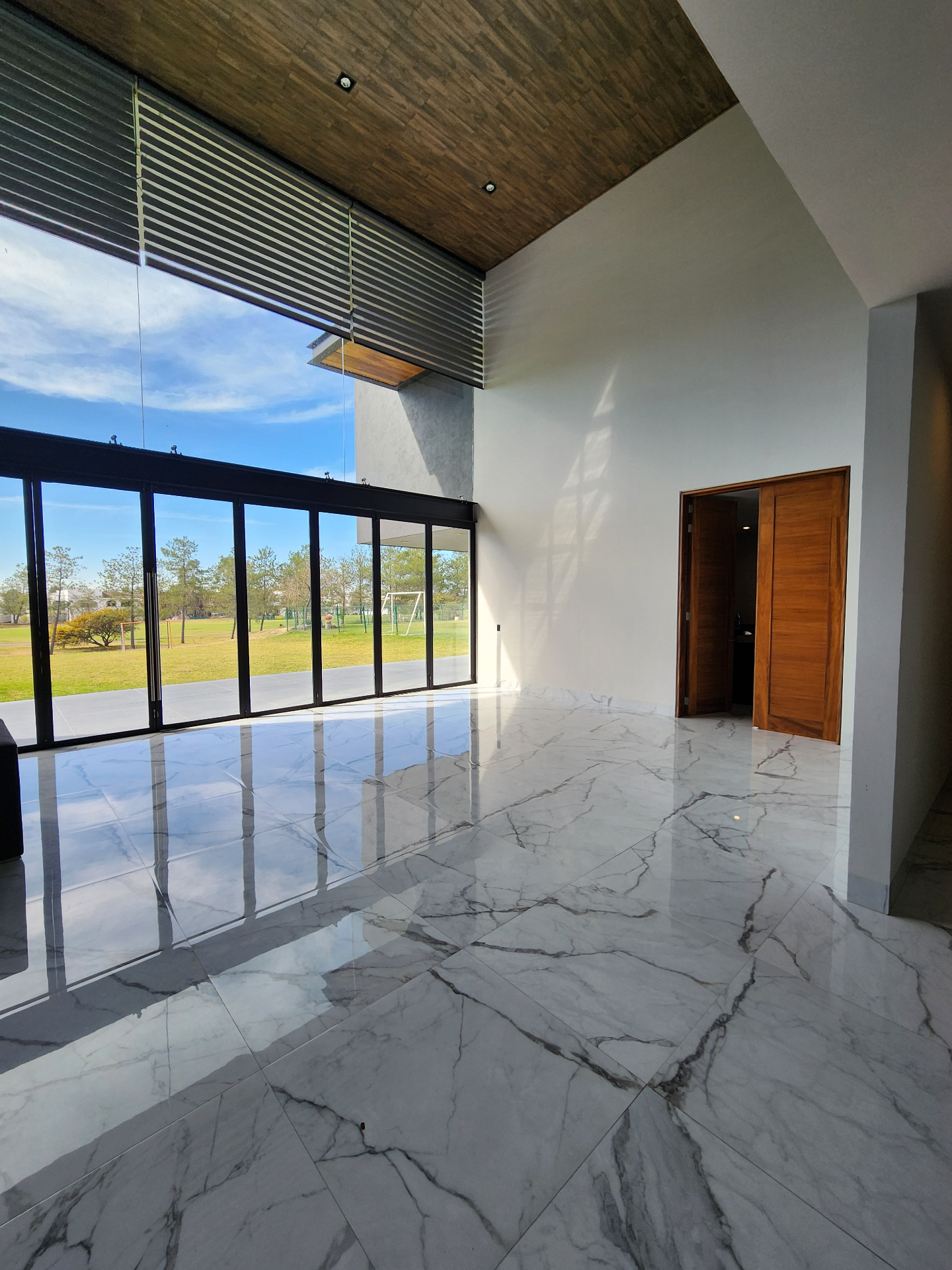 Sala con doble altura y ventanal al campo de golf
