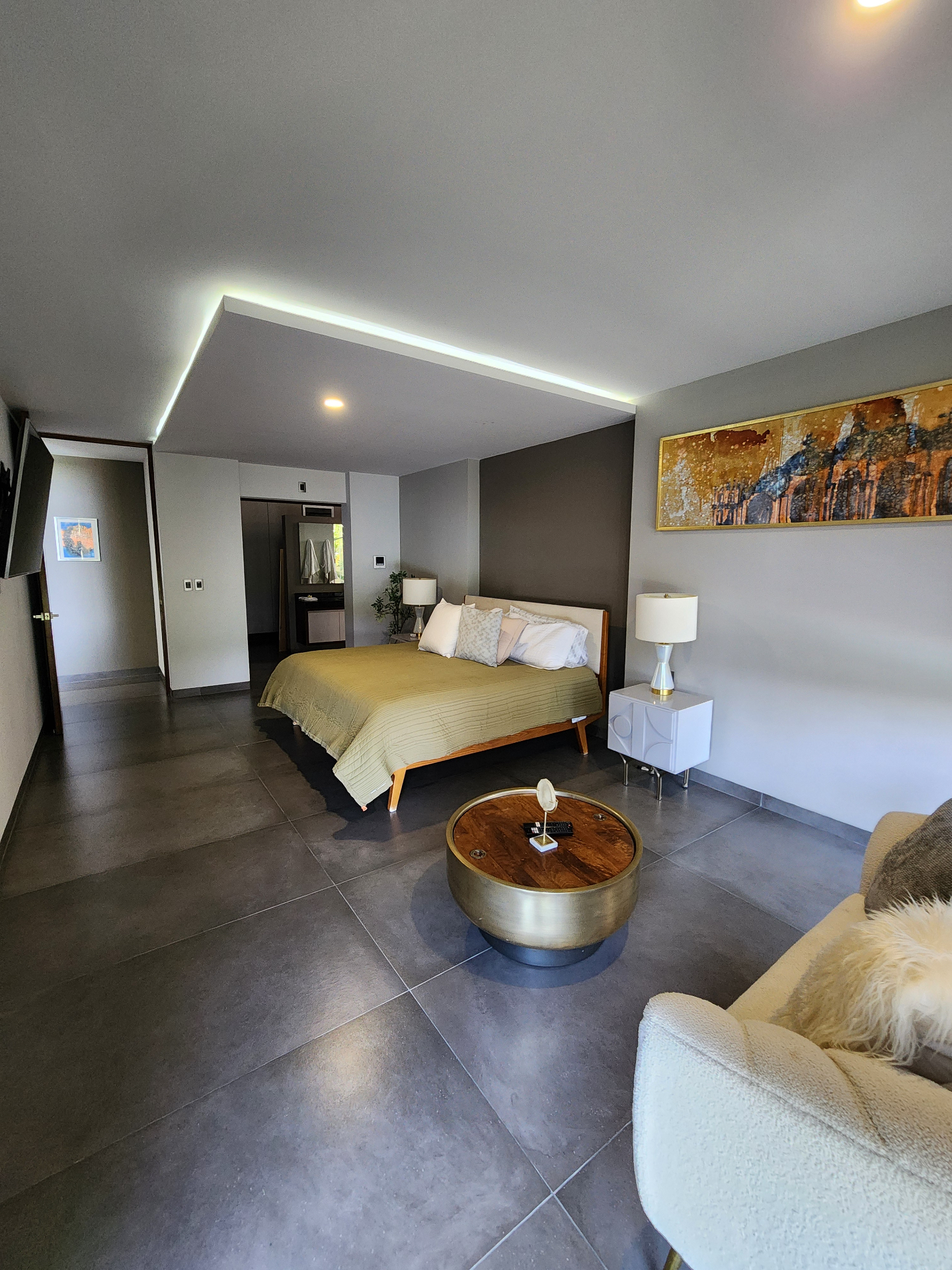 Habitación principal con sala de estar y acceso al vestidor y baño