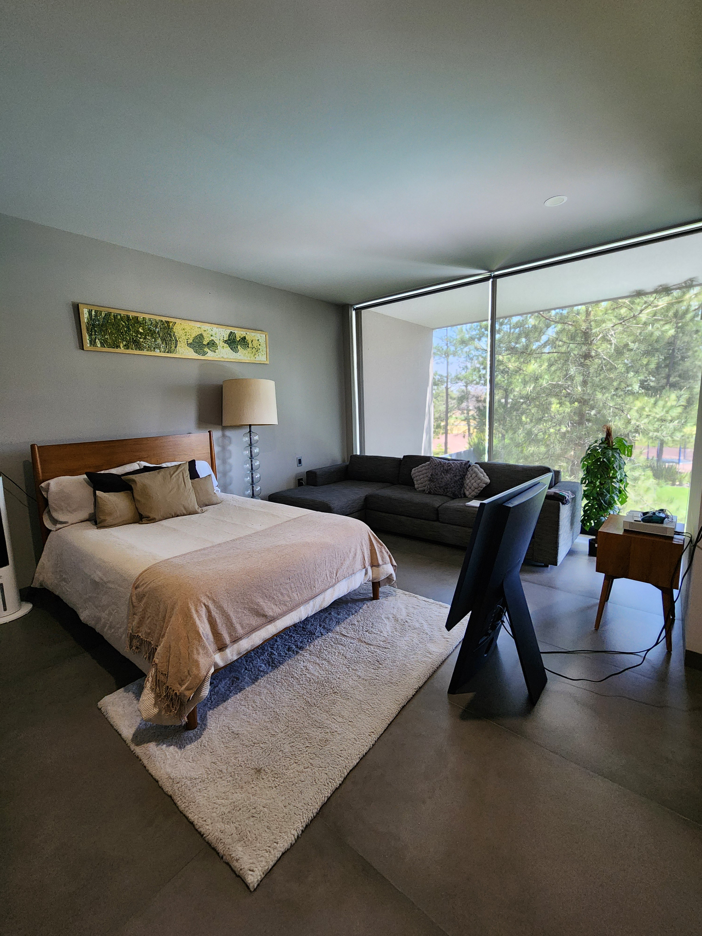 Recámara con sala de estar y ventanal de piso a techo al jardín