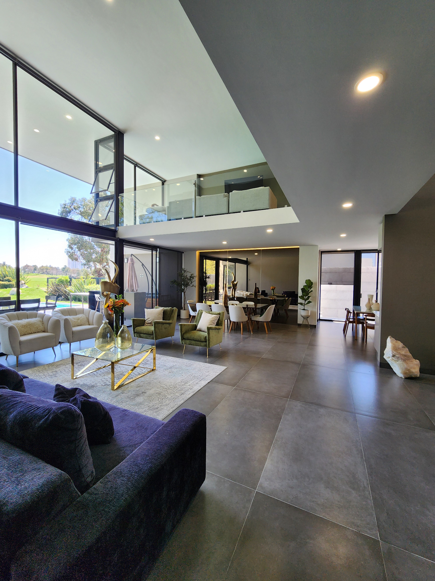 Sala principal de doble altura con ventanal panorámico al golf