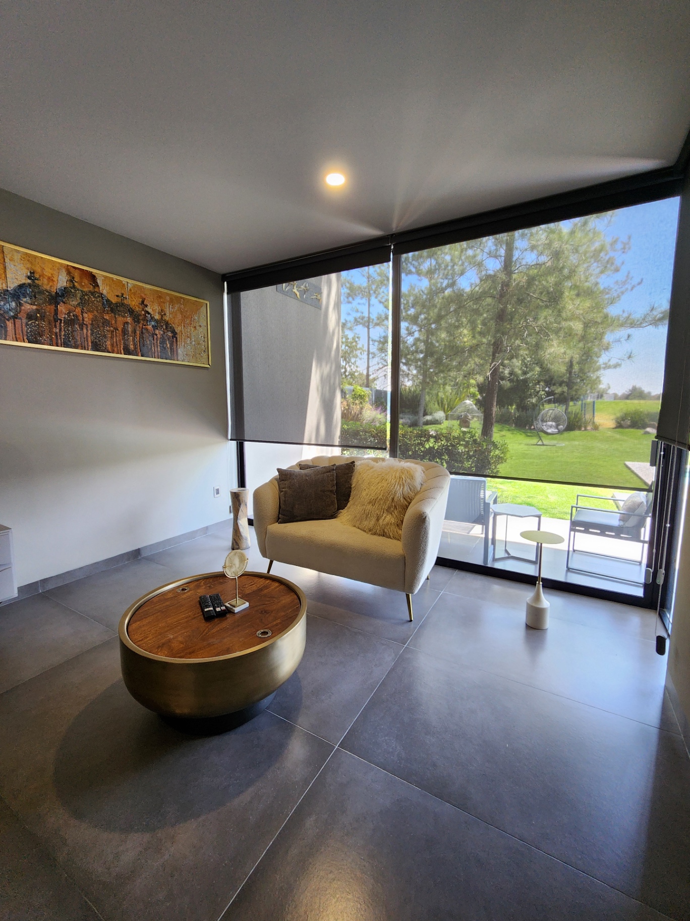 Sala de estar con ventanal de piso a techo y vista al jardín