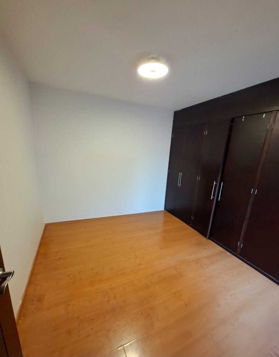 Recámara con closets de madera de piso a techo