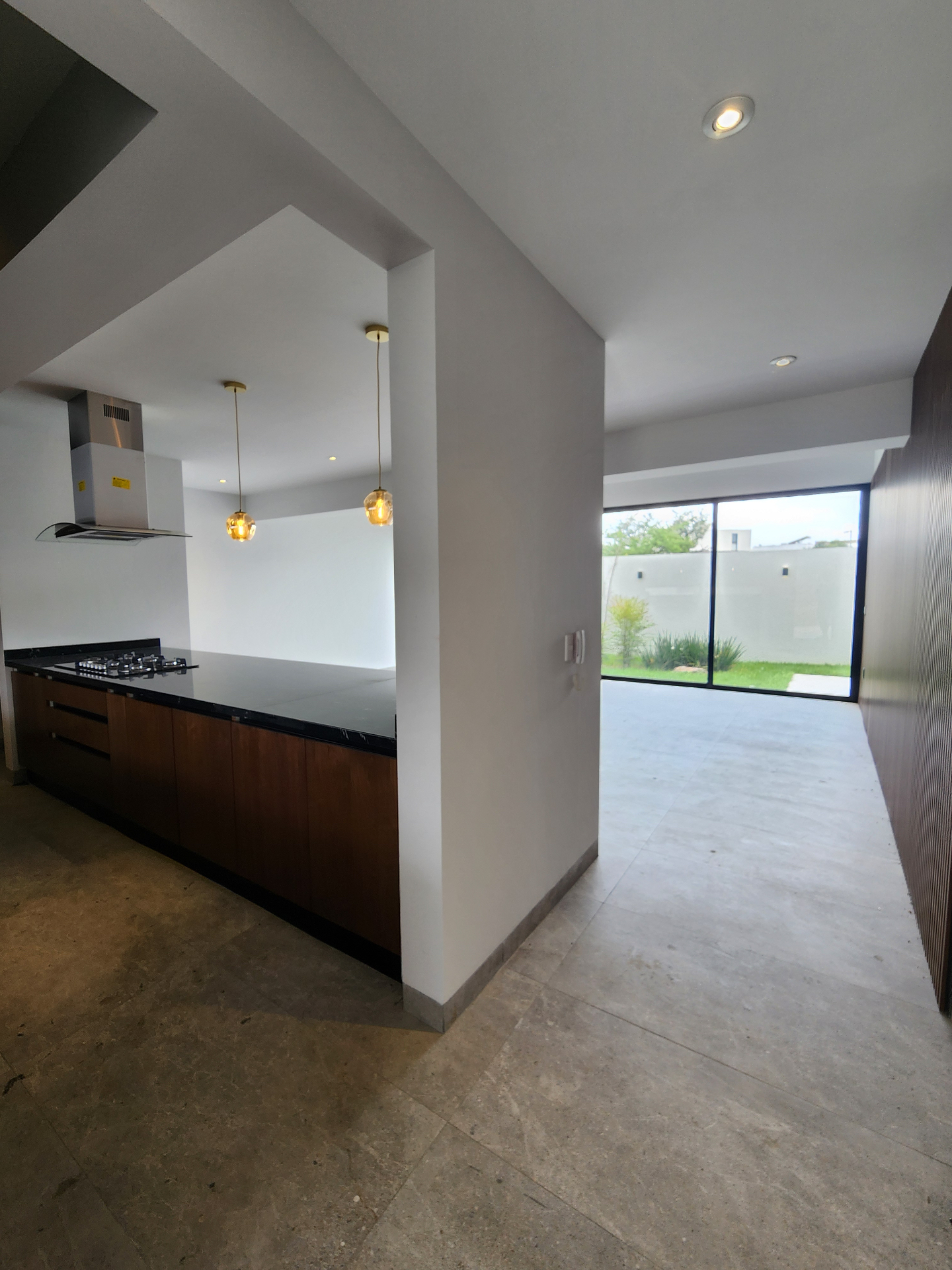 Cocina integral con vista al jardín y acceso al área social