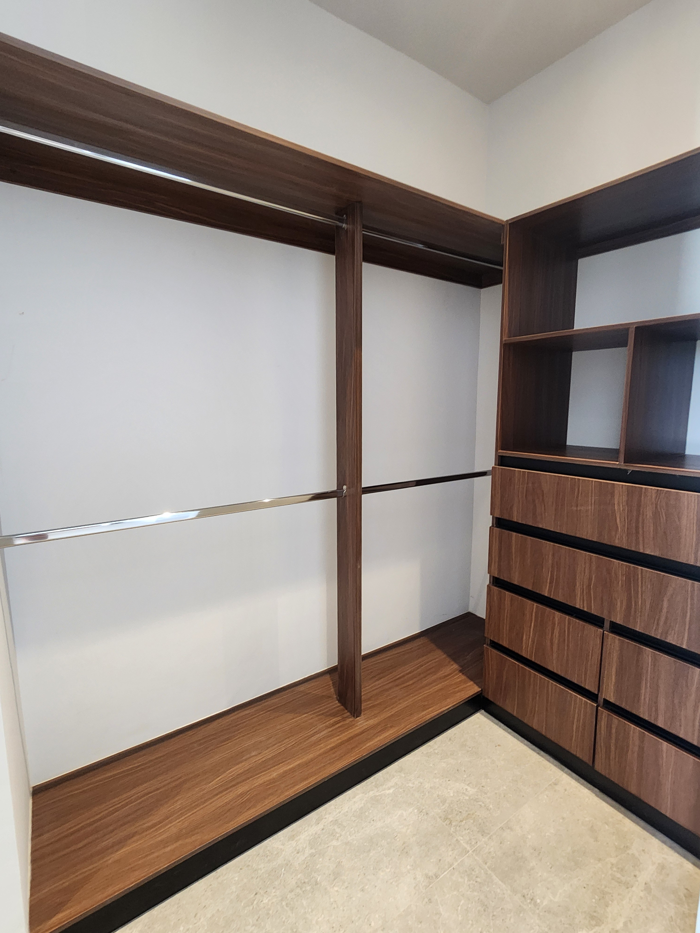 Vestidor en carpintería de madera con cajonería integrada, entrepaños abiertos y doble tubo para colgar