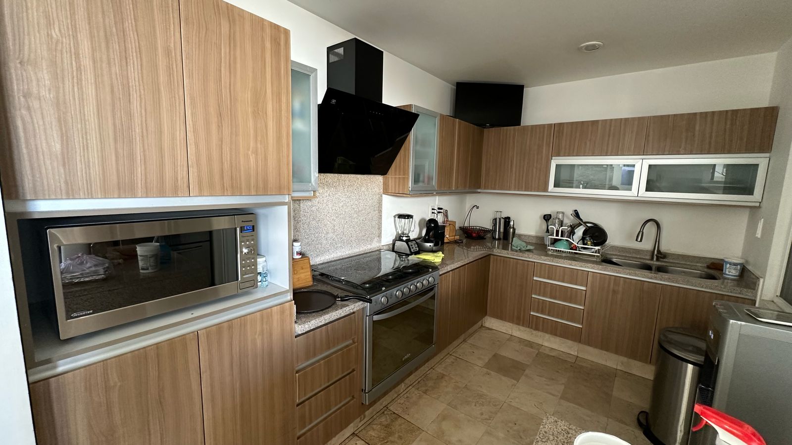 Cocina equipada con campana, parrilla, horno y barras de granito