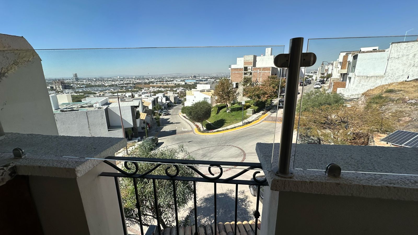 Vista panorámica de la ciudad desde la terraza con barandal de cristal